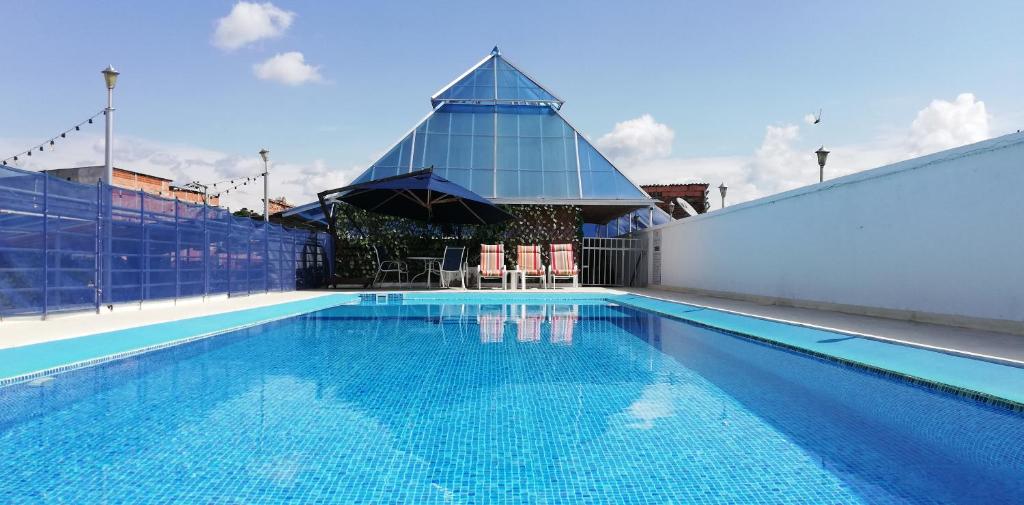 ein Pool mit einem Gebäude mit einem Sonnenschirm in der Unterkunft Magdalena Imperial Hotel in Girardot