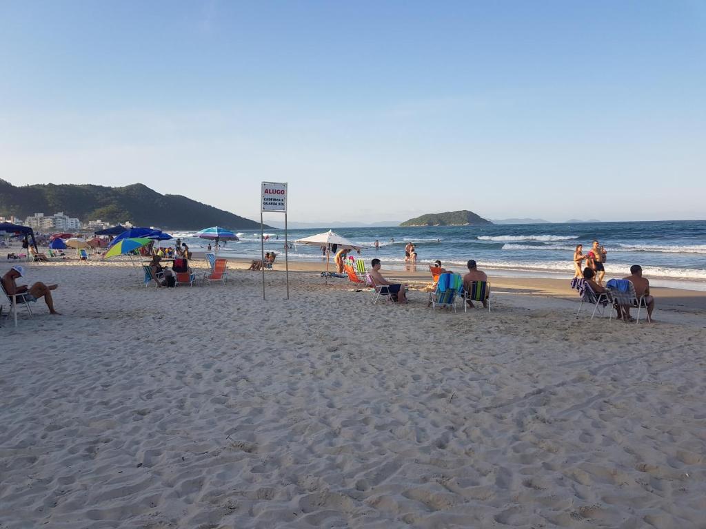 un grupo de personas sentadas en sillas en una playa en Praia palmas do arvoredo, en Governador Celso Ramos