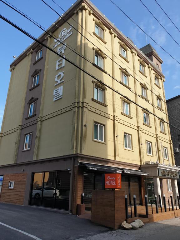 un edificio amarillo con un cartel en el costado en The Beauty Hotel, en Gangneung