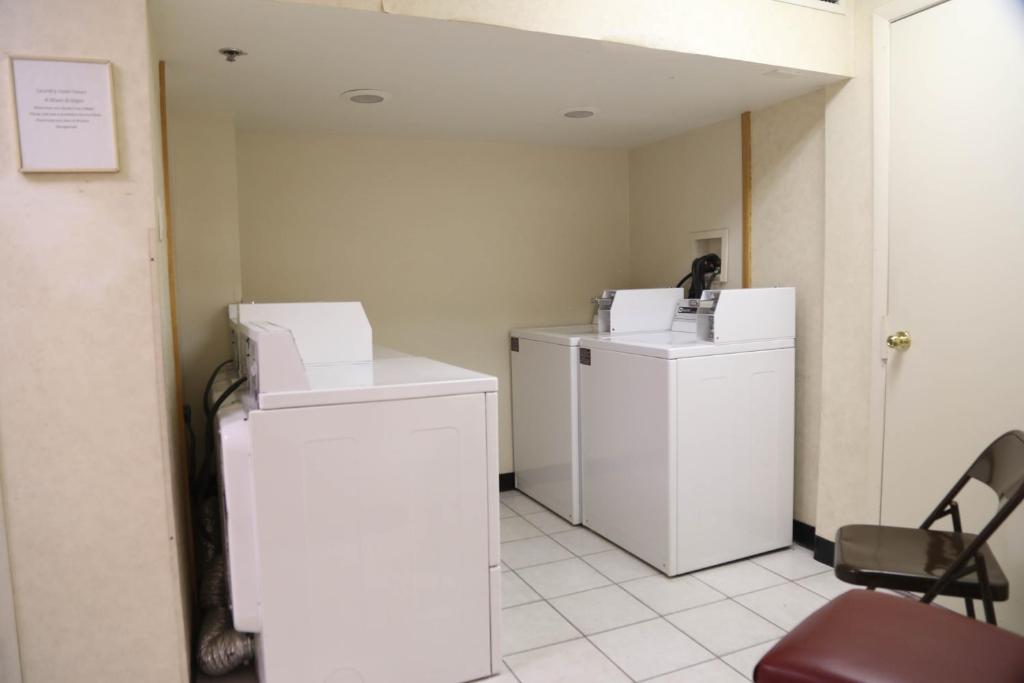 a laundry room with two washes and two dryers at Destiny Palms Hotel Maingate West in Kissimmee