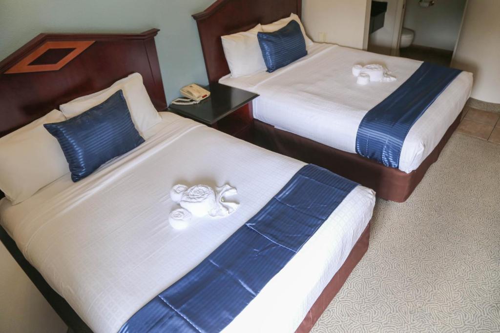 two beds in a hotel room with towels on them at Destiny Palms Hotel Maingate West in Kissimmee
