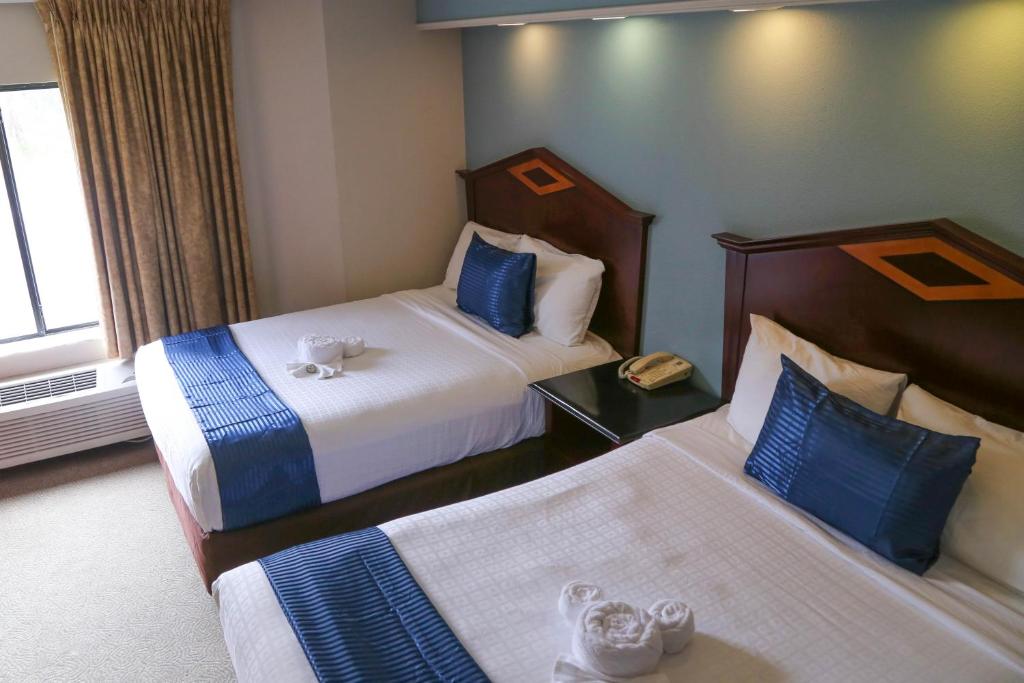 a hotel room with two beds with blue and white at Destiny Palms Hotel Maingate West in Kissimmee