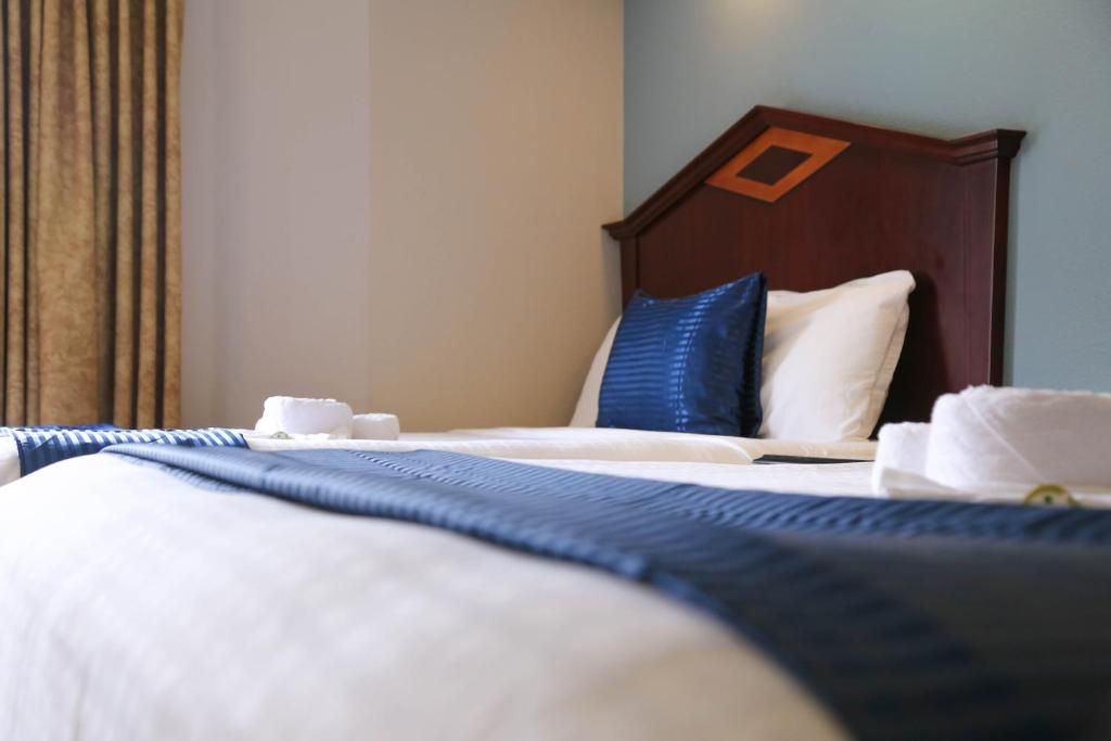 a hotel room with a bed with blue and white sheets at Destiny Palms Hotel Maingate West in Kissimmee