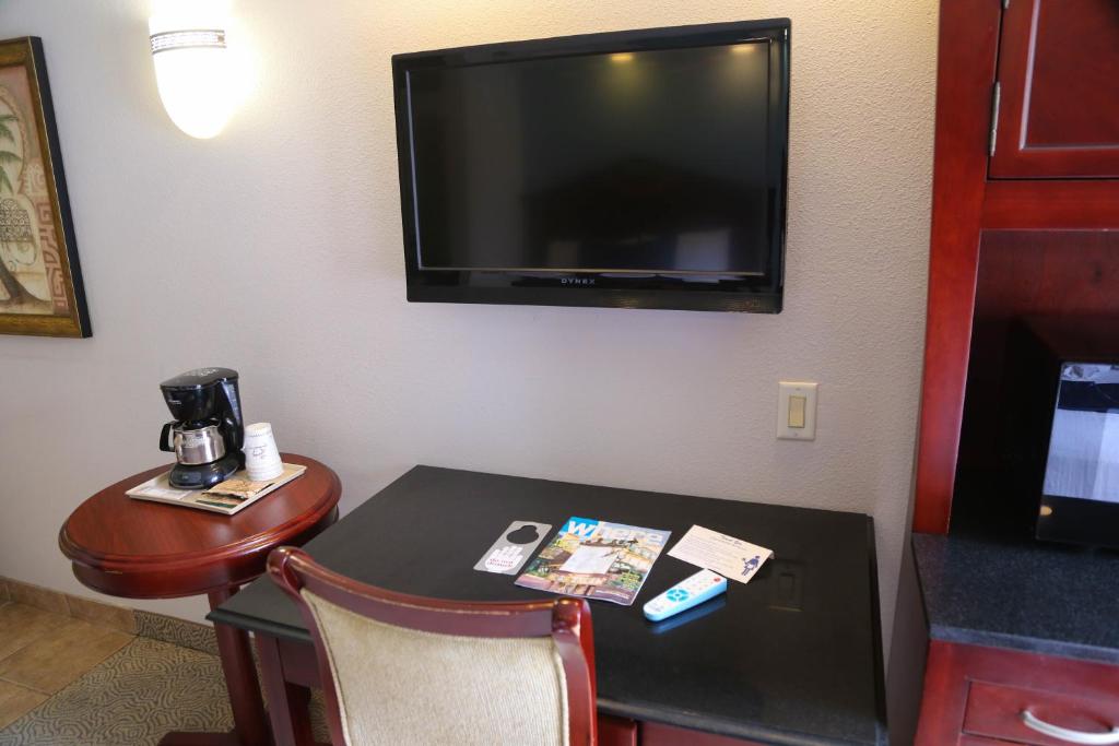 a hotel room with a table and a tv at Destiny Palms Hotel Maingate West in Kissimmee