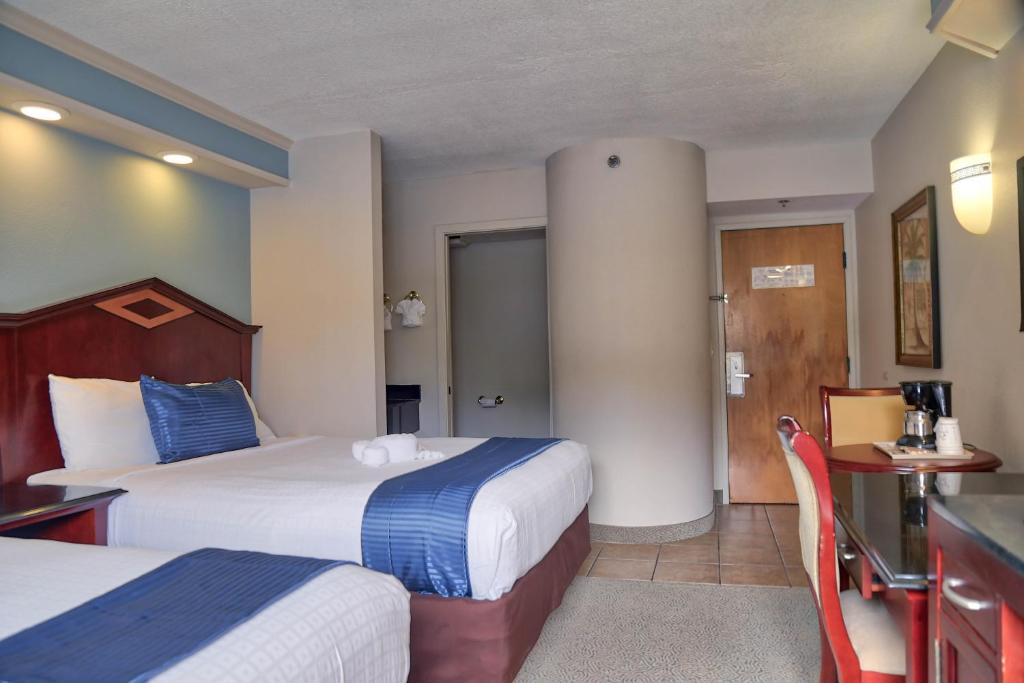 a hotel room with two beds and a bathroom at Destiny Palms Hotel Maingate West in Kissimmee