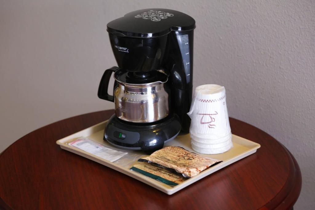 a coffee maker sitting on a table next to a paper towel at Destiny Palms Hotel Maingate West in Kissimmee
