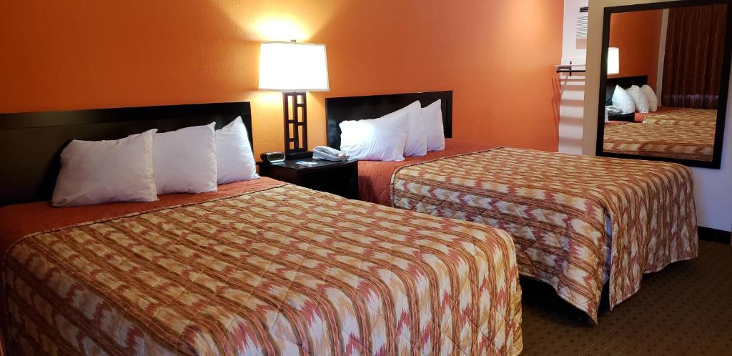 Habitación de hotel con 2 camas y espejo en Howard Johnson by Wyndham Flagstaff University West en Flagstaff