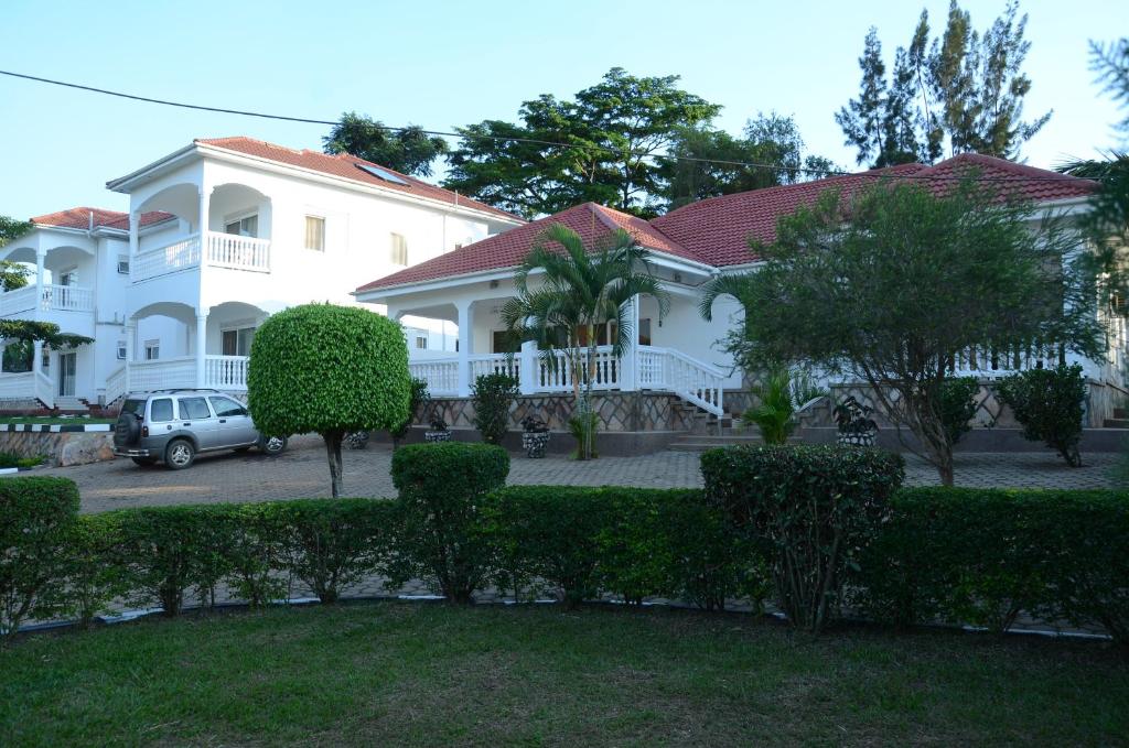 a white house with a car parked in front of it at Muyenga Luxury Vacation Home in Kampala