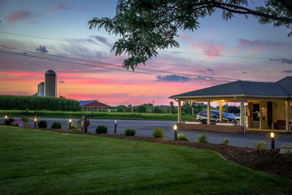 a house with a gazebo with a sunset in the background at Harvest Drive Family Inn - Renovated Rooms in Gordonville