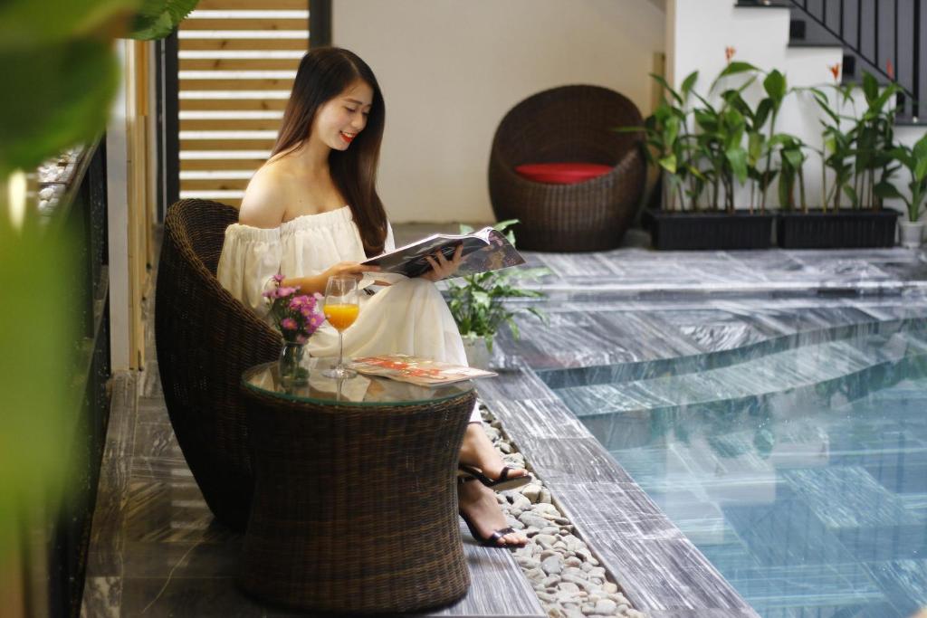 A staged poolside scene shows a wicker chair, refreshments, and the tiled edge of the water.