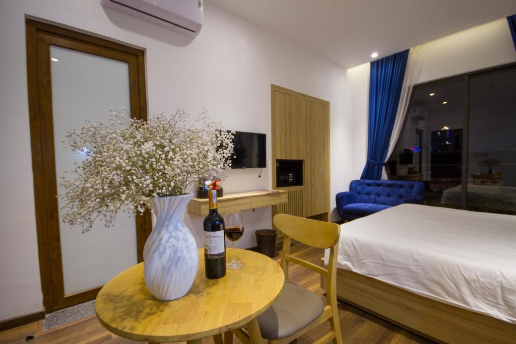 A styled double room with a small dining table, wine setting and blue sofa by the window.