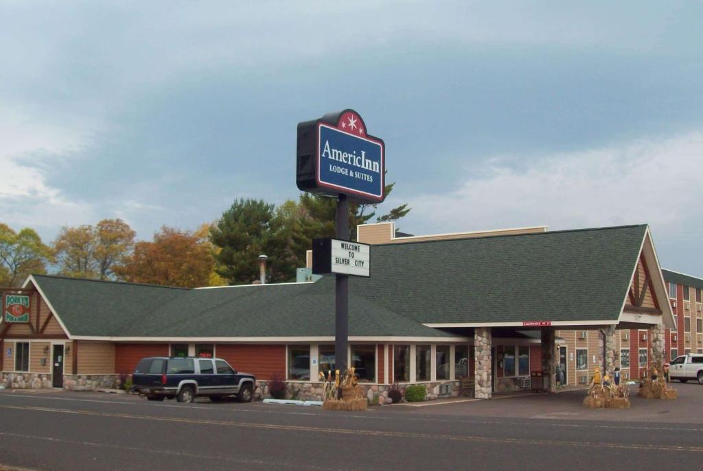 un edificio con una señal delante de él en AmericInn by Wyndham Silver City en Silver City