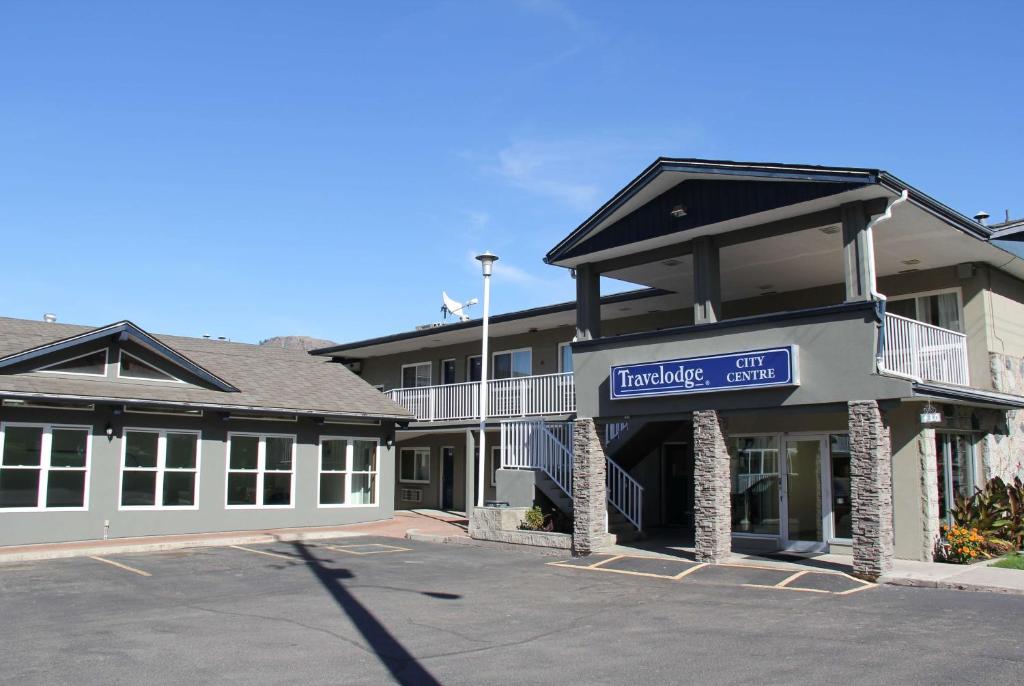 a building with a sign for a hotel at Travelodge by Wyndham Kamloops in Kamloops