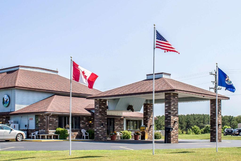 drei Flaggen vor einem Gebäude in der Unterkunft Quality Inn & Suites in Newberry