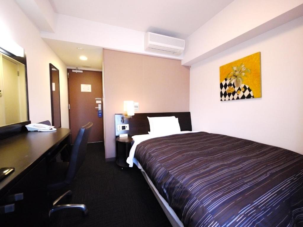 Postel nebo postele na pokoji v ubytování Hotel Route-Inn Yokohama Bashamichi