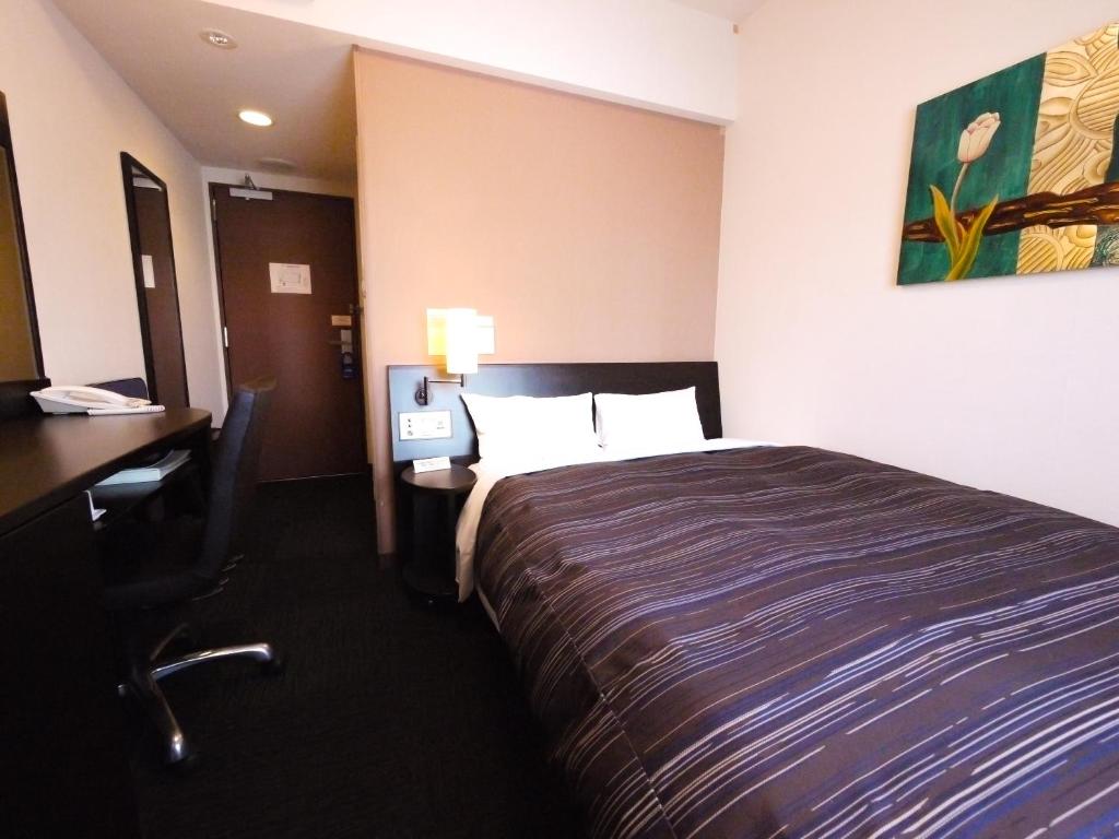 Postel nebo postele na pokoji v ubytování Hotel Route-Inn Yokohama Bashamichi