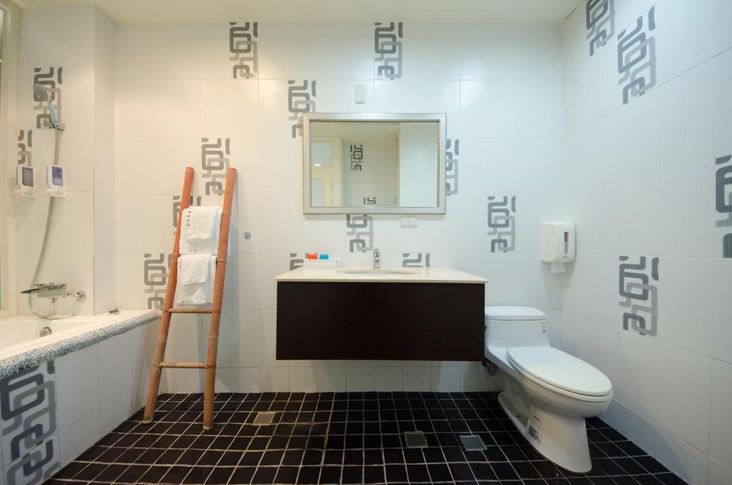 a bathroom with a toilet and a sink and a mirror at 岸戀民宿 墾丁船帆石 in Eluan