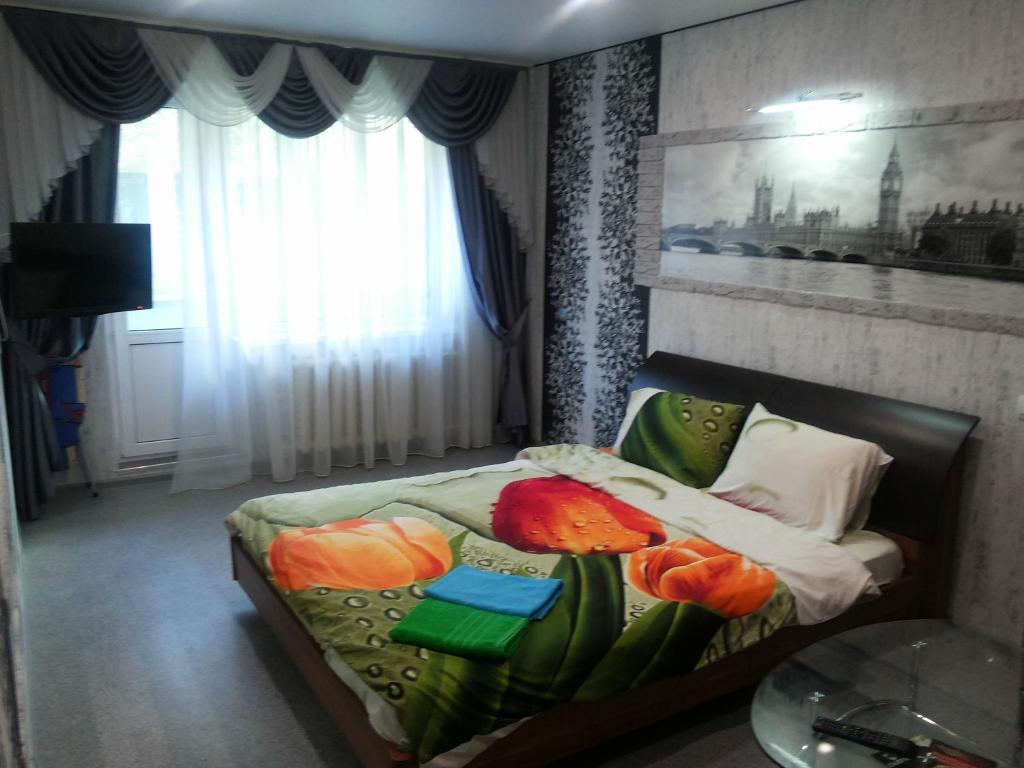 イヴァノヴォにあるApartment on Pervaya Polevayaのベッドルーム1室(花の飾られたベッド1台付)