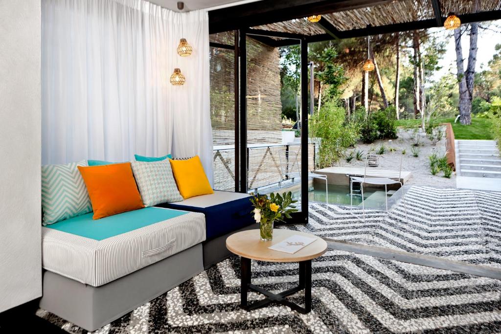 a living room with a couch and a table at Ekies All Senses Resort, a Member of Design Hotels in Vourvourou