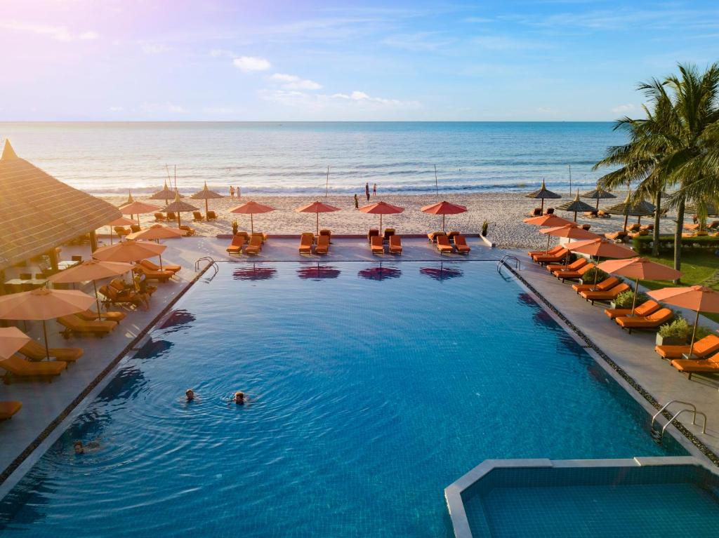 an overhead view of a swimming pool with umbrellas and the beach at Terracotta Resort & Spa in Mui Ne