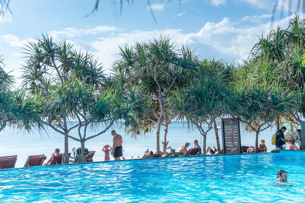 people in the infinity pool at the beach resort at Lanta Miami Resort - SHA Extra Plus in Ko Lanta