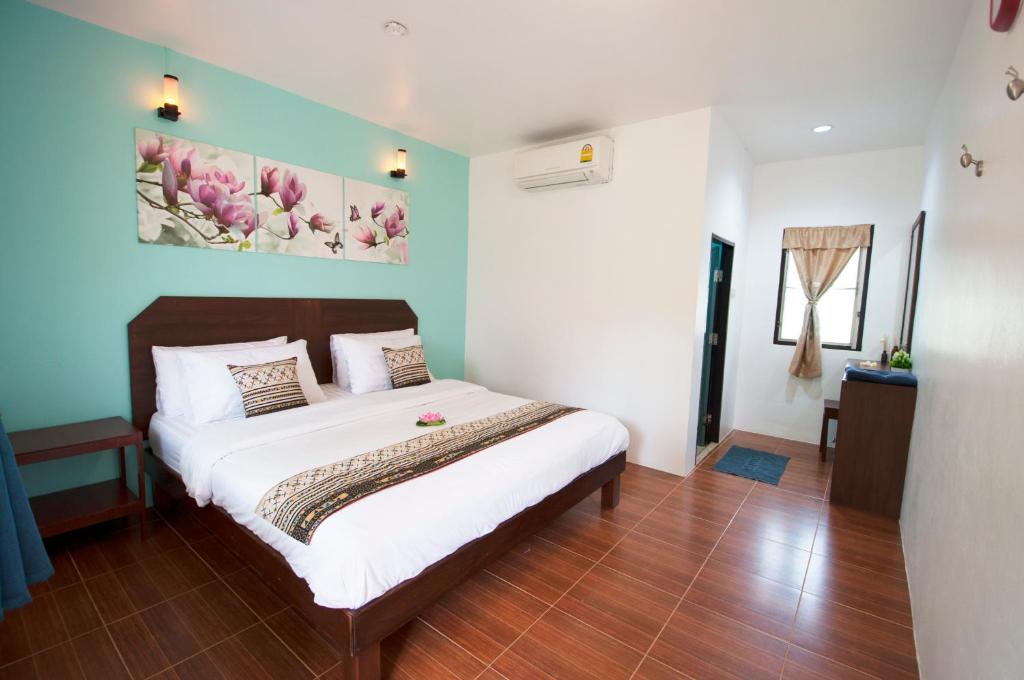 een slaapkamer met een bed en een schilderij aan de muur bij Yoghurt Home 3 in Haad Rin