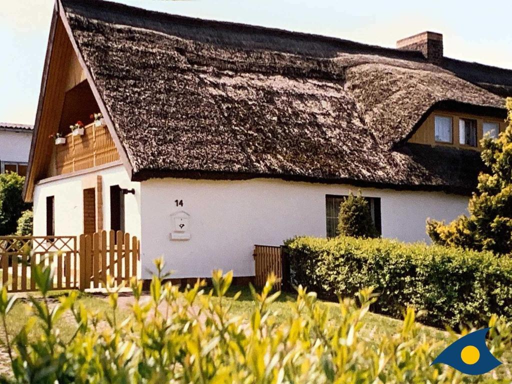 ein großes weißes Haus mit einem Strohdach in der Unterkunft Haus Ückeritz Parterrewohnung in Ückeritz