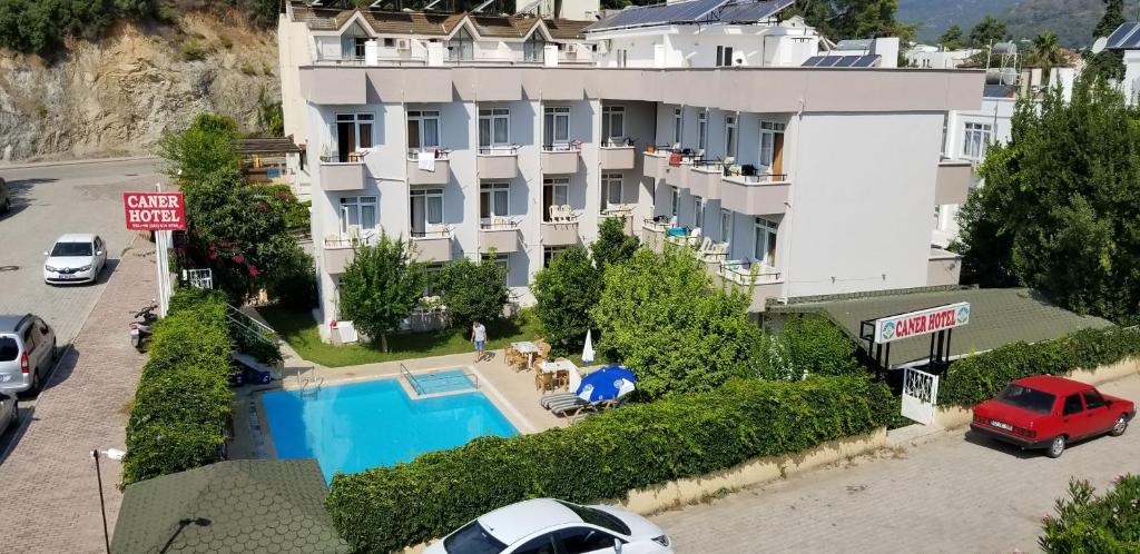 a large white building with a swimming pool at Caner Hotel in Kemer