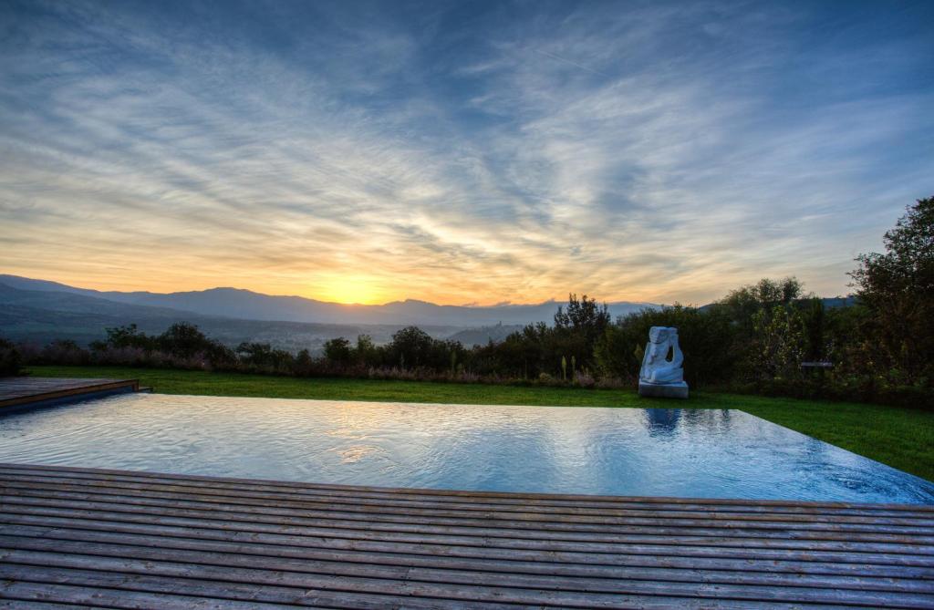 - une piscine avec vue sur le coucher du soleil en arrière-plan dans l'établissement Villa Chimera, à Poppi