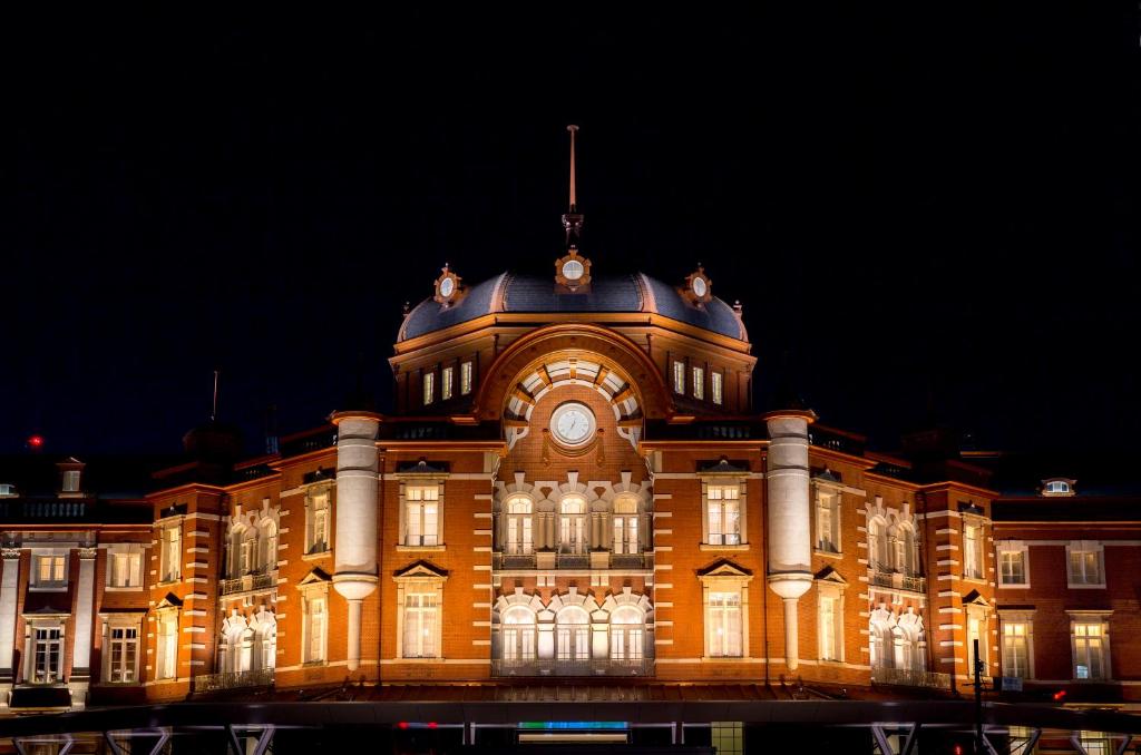 a large building with a clock on it at night at The Tokyo Station Hotel in Tokyo