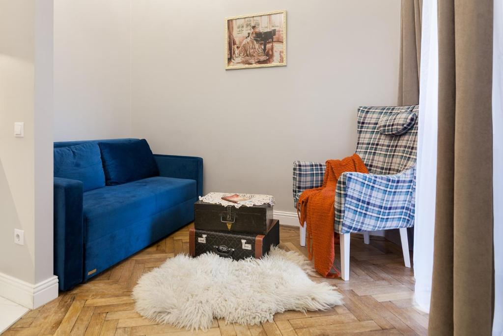 リヴィウにあるChopin Apartment in the center of Lvivのリビングルーム(青いソファ、椅子2脚付)