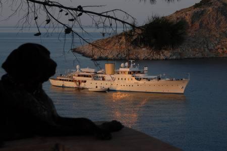 a boat in the water with a person looking at it at Tramontana in Hydra