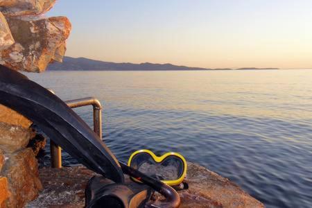 a pair of scissors sitting on the side of the water at Tramontana in Hydra