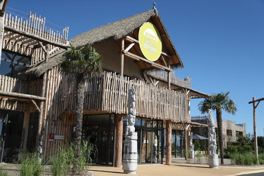 a building with palm trees in front of it at Les Hauts de Beauval in Saint-Aignan