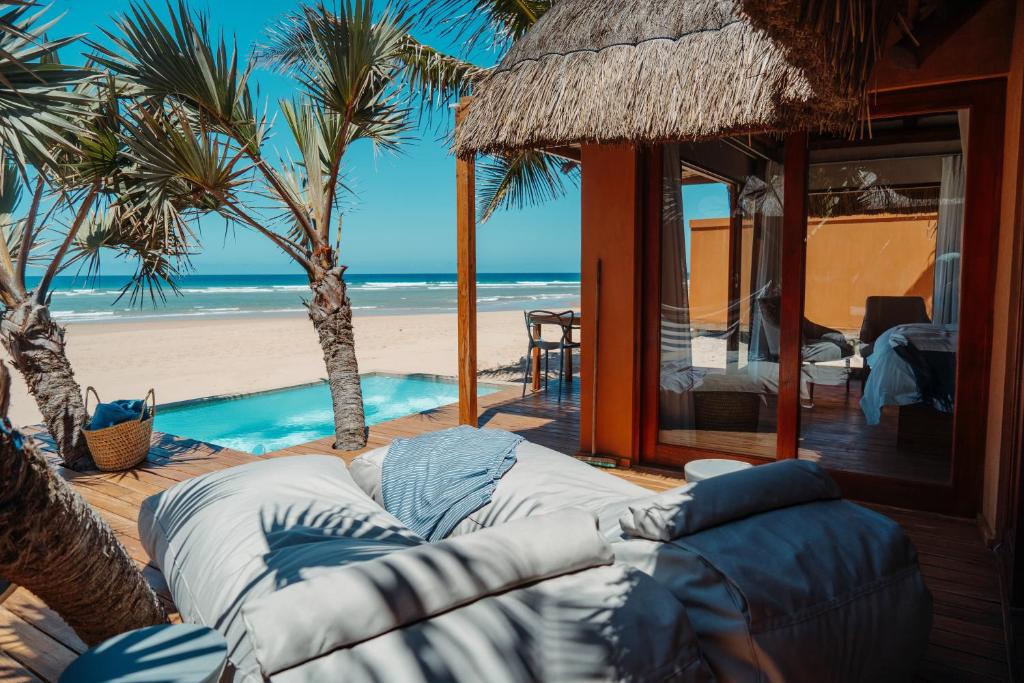 Eclectic Beach Retreat في Cabo Nhamua: غرفة معيشة مع أريكة على الشاطئ
