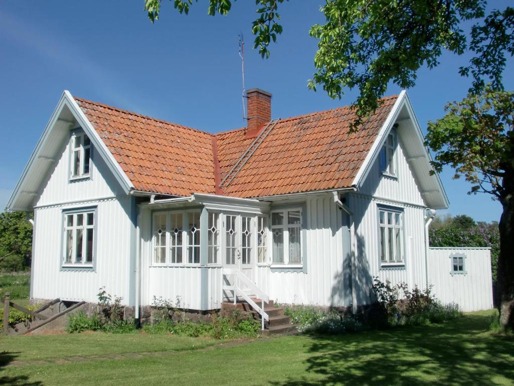 una casa blanca con techo naranja en Bond-Gården, en Fågelmara