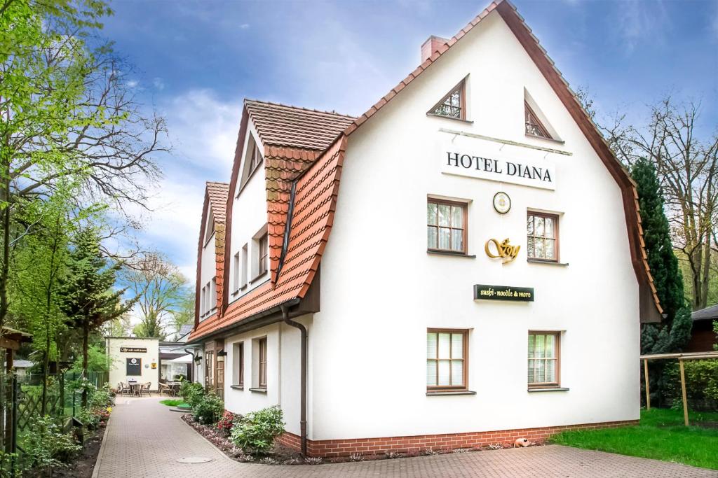 a white building with a sign that reads hotel dijon at Hotel Diana in Schönwalde