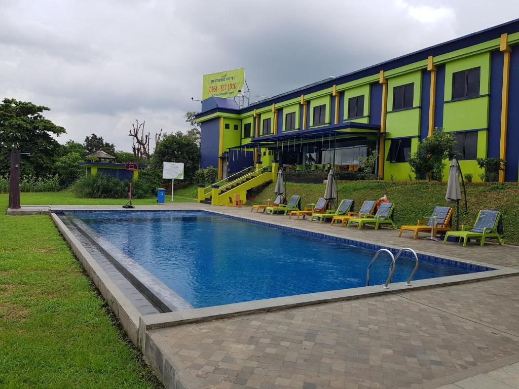 a hotel with a swimming pool in front of a building at PrimeBiz Hotel Karawang in Cikampek