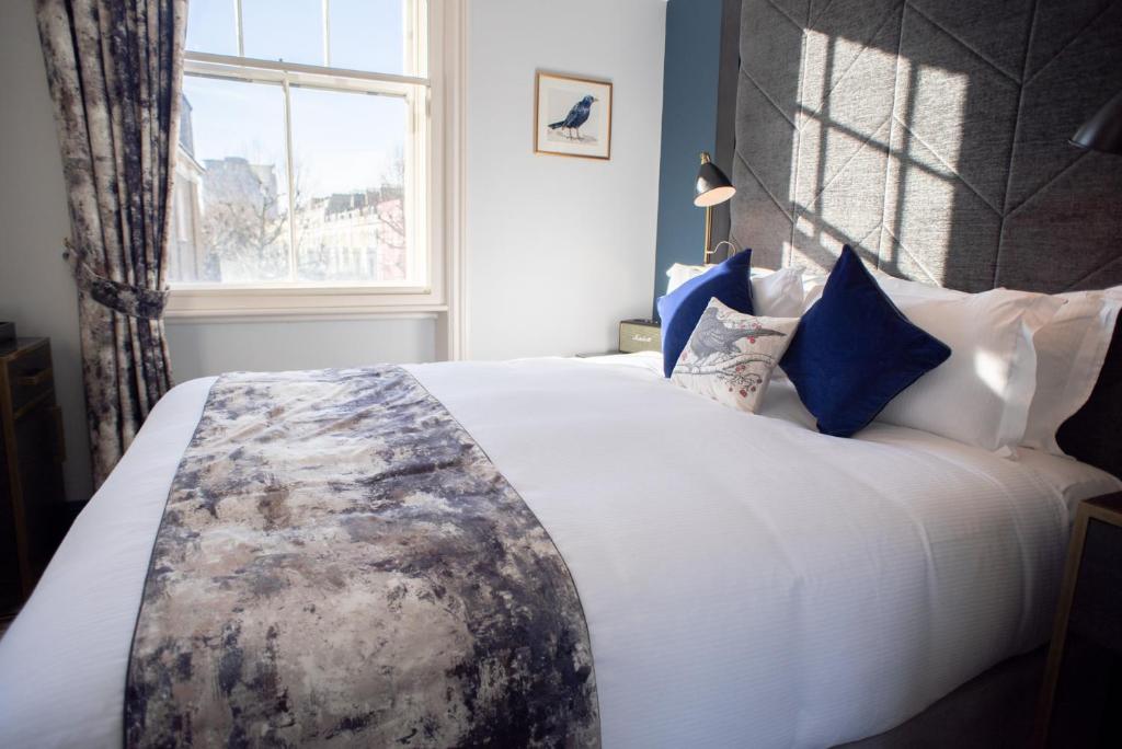 a bed with a white comforter and pillows at Blackbird in London
