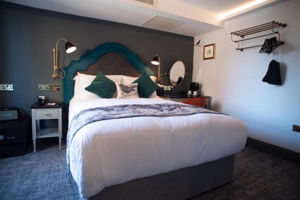 1 dormitorio con 1 cama grande y espejo en Blackbird, en Londres