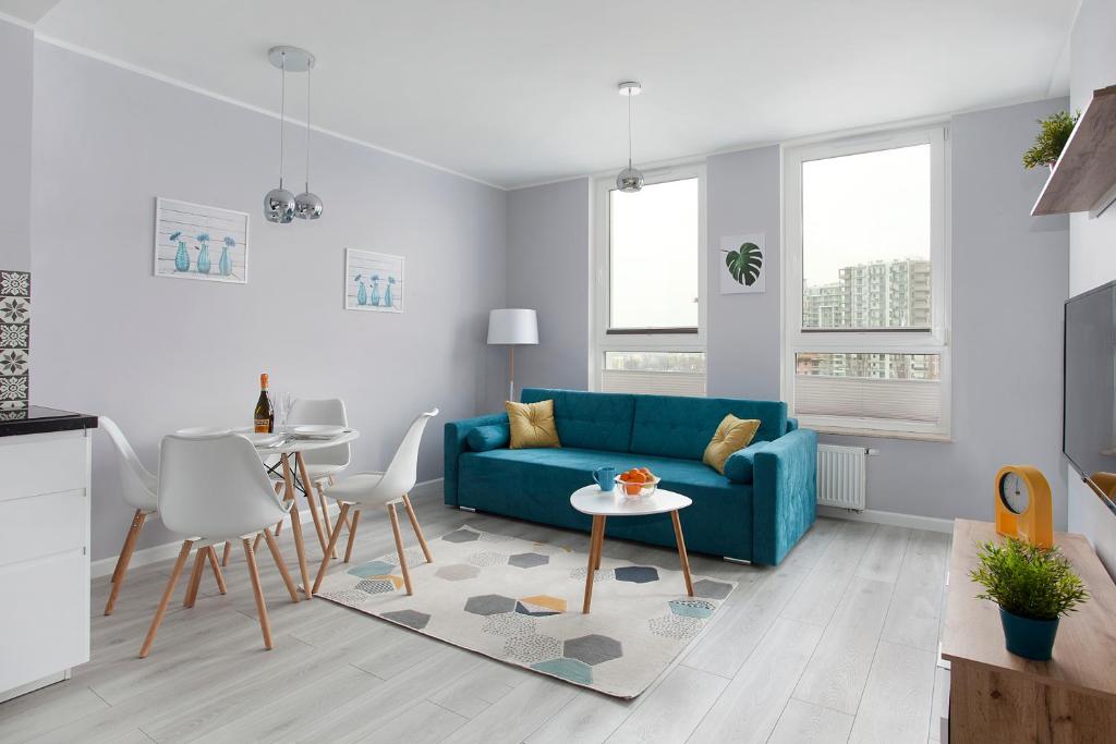 sala de estar con sofá azul y mesa en Luxury Apartment Solvo, en Gdansk