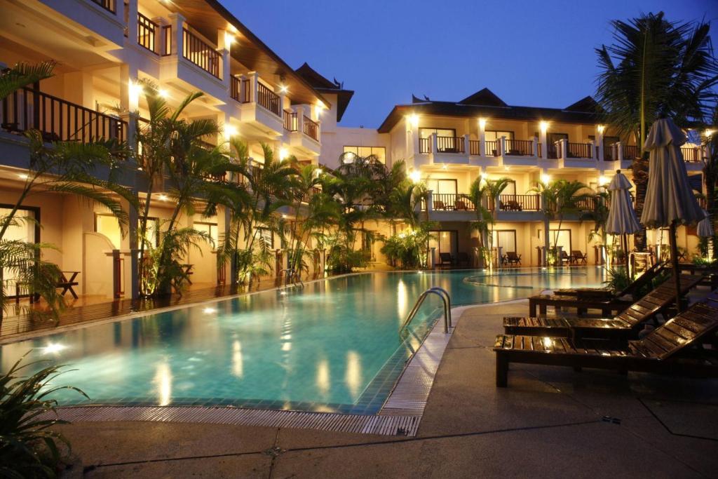 a large swimming pool in a hotel at night at Fanari Khaolak Resort - Courtyard SHA Extra Plus in Khao Lak