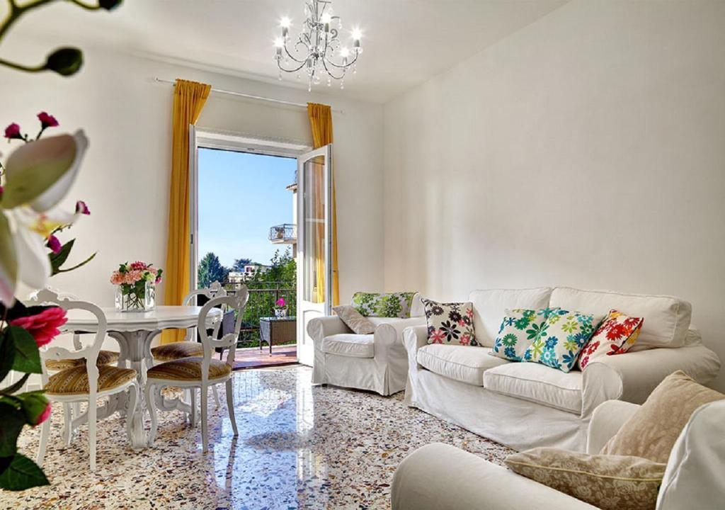 a living room with a white couch and a table at Stella House in SantʼAgata sui Due Golfi