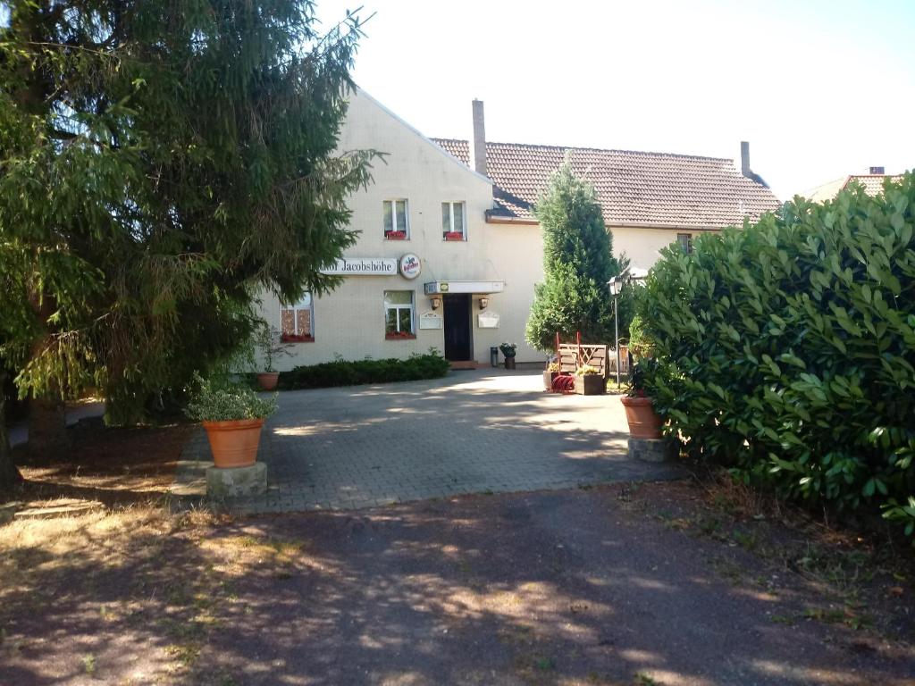 a white building with a driveway in front of it at Gasthof Jacobshöhe in Kloster GrÃ¶ningen