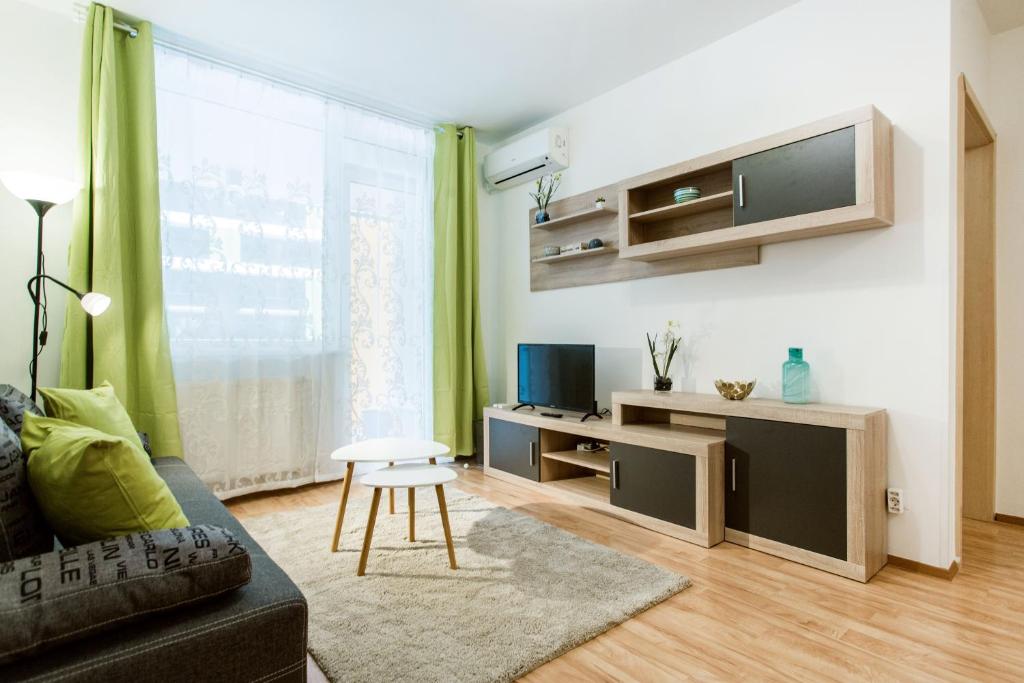 uma sala de estar com um sofá e uma mesa em Corvin 4 Sun Resort Apartment em Budapeste