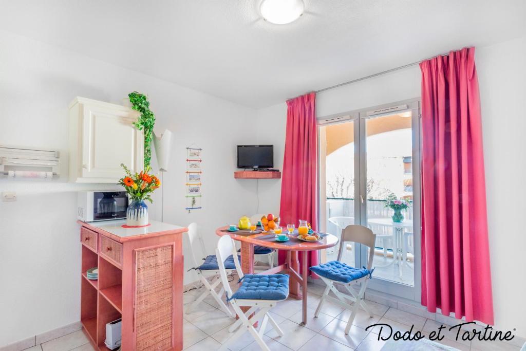 uma cozinha com mesa e cadeiras e uma janela em Quiet cute 1 bedroom with terrace - Dodo et Tartine em La Londe-les-Maures