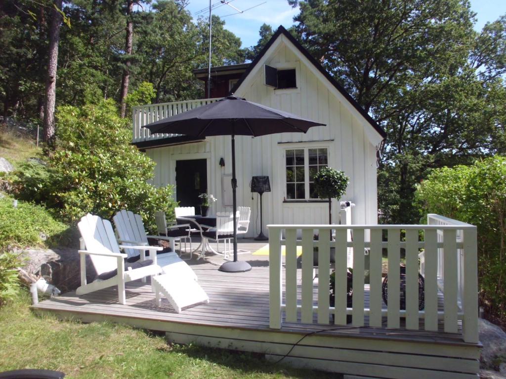 eine Hütte mit einem Sonnenschirm und Stühlen auf einer Terrasse in der Unterkunft Det Vita Huset in Stockholm