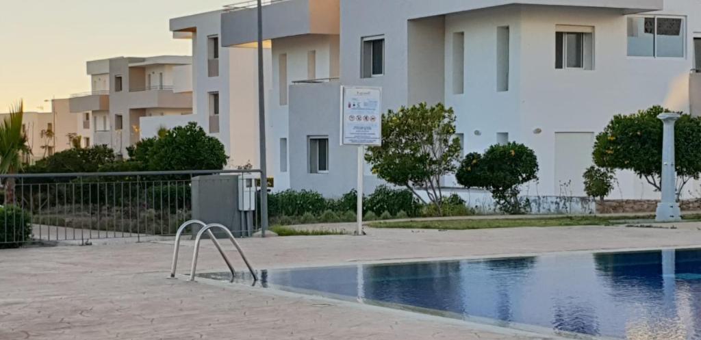 a swimming pool in front of some apartment buildings at Appartement meublé plage imi ouaddar lunja village agadir in Imi Ouaddar