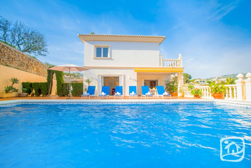 a villa with a swimming pool in front of a house at Villa La Marina by Abahana Villas in Benissa