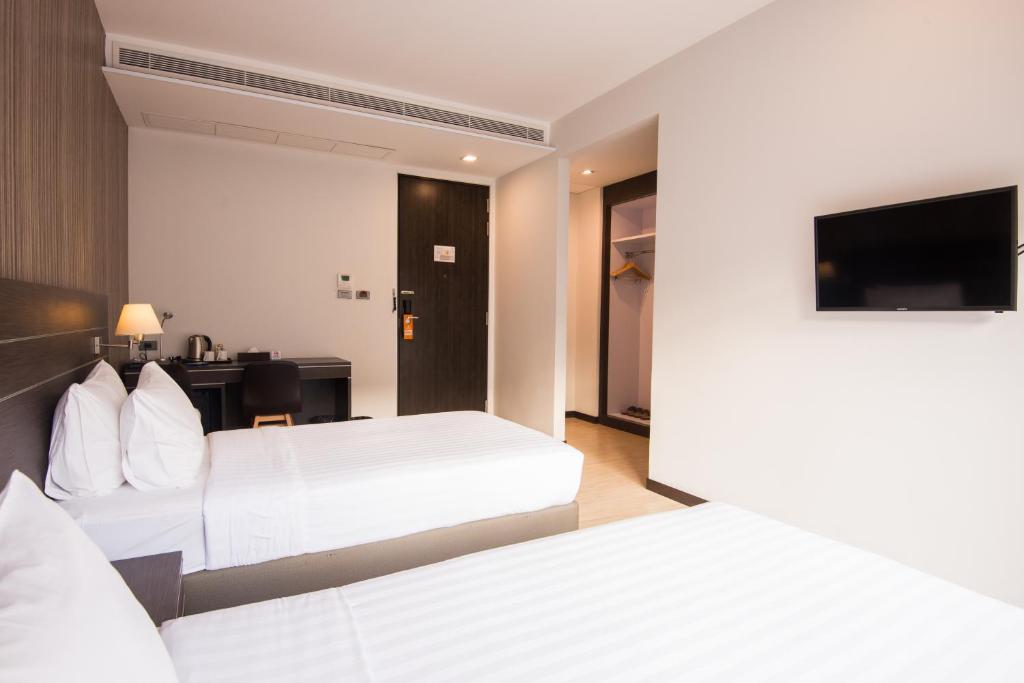 a hotel room with two beds and a television at Amanta Hotel Nongkhai in Nong Khai